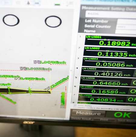 VF Decolletage quality control staff inspecting precision part with Keyence measurement machine