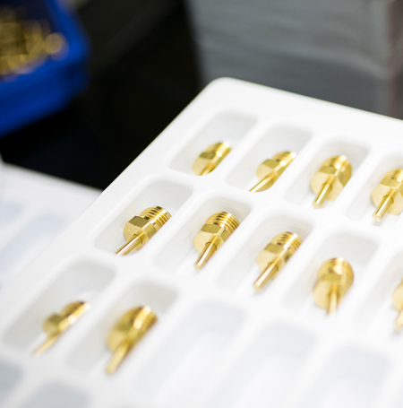 Close-up view of precision machined brass parts by VF Decolletage